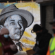 A mural featuring a portrait of civil rights icon Emmett Till looks out from an abandoned building front as volunteers gather nearby with family members of Tamiko Talbert-Fleming after passing out flyers in the Chicago Lawn neighborhood seeking information about her murder on January 19, 2022, in Chicago, Illinois.